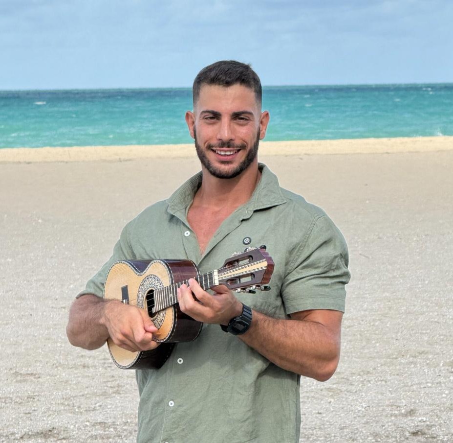 Tim, do Hebraico Juntos, com um cavaquinho na praia